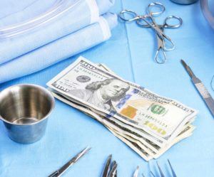 Calculator and clipboard estimating gynecomastia surgery cost